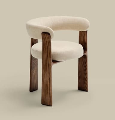 A modern armchair featuring a sculpted dark wood frame and cream-colored textile upholstery. The chair has a rounded, continuous backrest and armrests, and a circular seat cushion. The robust, splayed wooden legs provide a stable and aesthetically integrated base. — 3D model