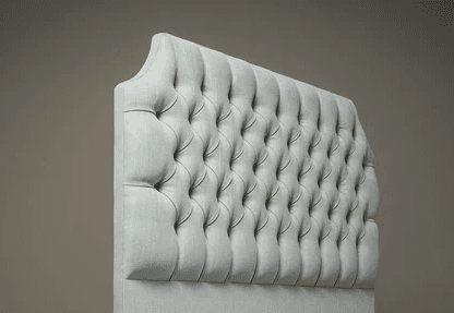 A light blue upholstered headboard with a tufted design. The tufting creates a diamond pattern with buttons at each intersection. The headboard has a slightly arched top and is mounted on a base that is not fully visible. — 3D model