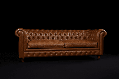 A classic Chesterfield sofa upholstered in rich brown leather, featuring distinctive button tufting on the backrest, rolled arms, and front apron. It has two separate seat cushions and stands on short, turned wooden feet. — 3D model