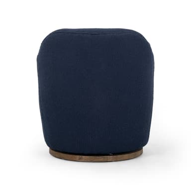 A contemporary armchair upholstered in a textured navy blue fabric. It features a rounded back and integrated armrests that curve gently downwards. The chair is supported by a circular, dark wood swivel base, allowing for 360-degree rotation. The upholstery has a boucle or similar textured finish. — 3D model