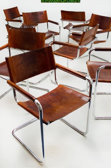A Bauhaus-style cantilever armchair featuring a polished tubular chrome frame and brown leather sling upholstery for the seat, backrest, and armrests. — 3D model