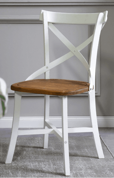 A white-framed dining chair with a natural wood seat and a distinctive criss-cross backrest. The frame appears to be made of painted wood, and the seat is a smooth, rounded wooden surface. The backrest is constructed from two curved white wooden pieces that cross in the center, attached to the top rail and the seat frame. — 3D model