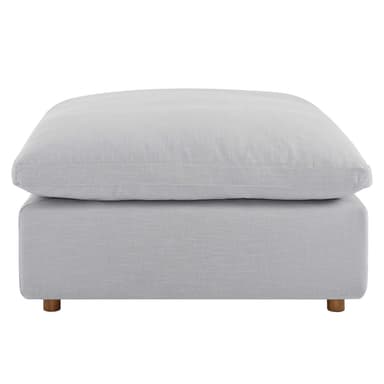 A modern, square-shaped ottoman featuring a light gray, linen-look fabric upholstery. It consists of a plush, oversized top cushion resting on a slightly smaller, more rigid base, supported by small, subtly splayed wooden feet. — 3D model