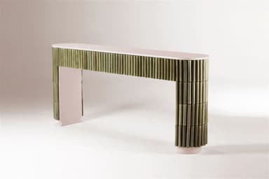 An elongated, narrow console table featuring a light pinkish-beige top and structural elements. The front and sides are extensively clad with vertical, muted green cylindrical elements, likely ceramic rods, creating a fluted or reeded texture. The base of the table follows the same pinkish-beige tone and features a subtle arched shape. — 3D model
