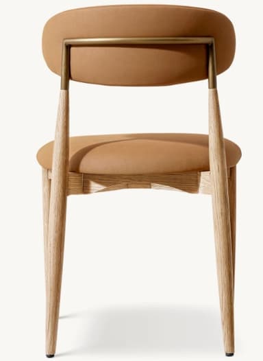 A contemporary dining chair featuring a light oak wood frame and light brown upholstered seat and backrest. The design is minimalist with tapered legs and gently curved padded elements. — 3D model