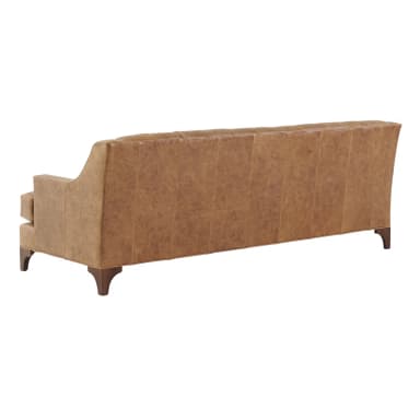 A tufted leather sofa with a camel brown finish. The sofa features rolled arms, a high back with deep button tufting, and a skirted base with tapered wooden legs. — 3D model
