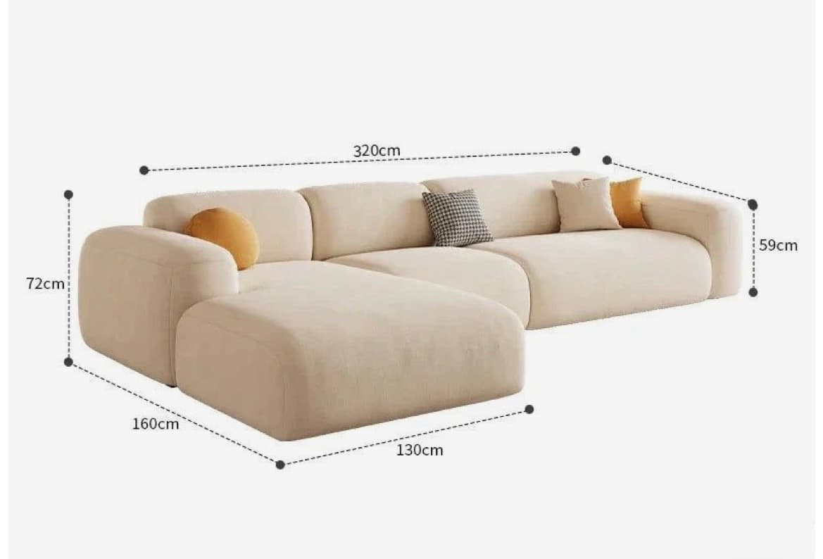 A sectional sofa with a chaise lounge attachment. The sofa features rounded edges and plush cushioning. It is upholstered in a textured, light-colored fabric and includes several throw pillows for added comfort and visual interest. — 3D model