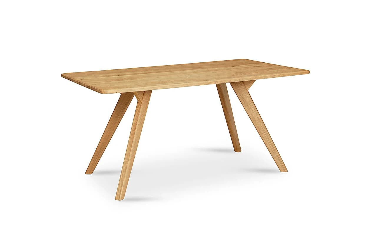A modern rectangular dining table crafted from light-colored solid wood. The tabletop features softly rounded edges, and it is supported by four robust, splayed legs that converge towards the center of the table before extending outwards at an angle, providing both stability and a distinctive aesthetic. The natural wood grain is visible, suggesting a clear finish. The design is minimalist and functional. — 3D model