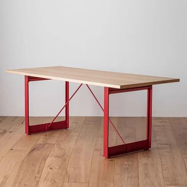 A modern rectangular table featuring a light wood tabletop and two striking red metal trestle bases. The design is minimalist and industrial-inspired, suitable for various contemporary settings. — 3D model