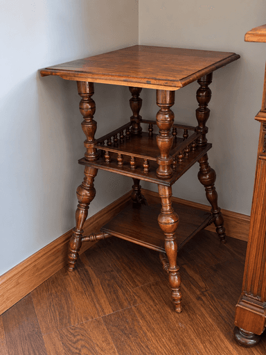 A traditional three-tiered accent table made from dark-stained wood. It features square surfaces, ornately turned legs, and a spindled gallery rail on the middle tier. — 3D model