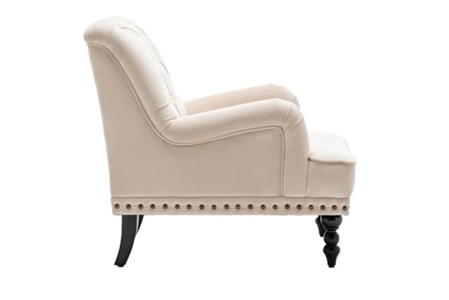 A traditional upholstered armchair featuring a light cream fabric, rolled armrests, a tufted backrest, and decorative nailhead trim along the base. The chair stands on dark-finished legs, with turned spool-shaped legs at the front and tapered saber legs at the rear. — 3D model