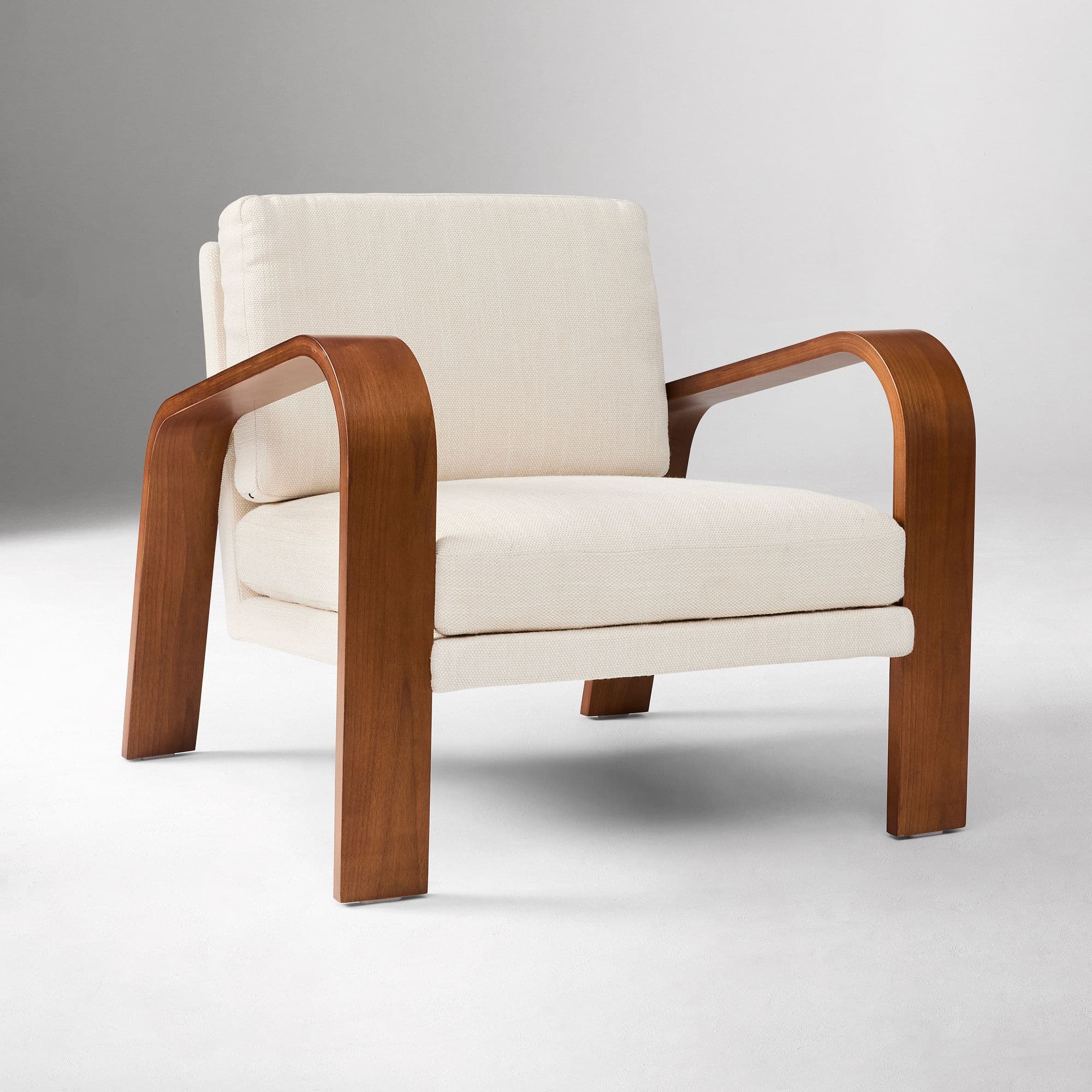 A contemporary armchair featuring a distinctive bentwood frame in a warm, medium brown finish, complemented by plush, off-white fabric cushions. The frame forms continuous, gracefully curved armrests and legs, providing a minimalist yet sturdy base. The design combines comfort with modern aesthetics, suitable for various interior styles. — 3D model