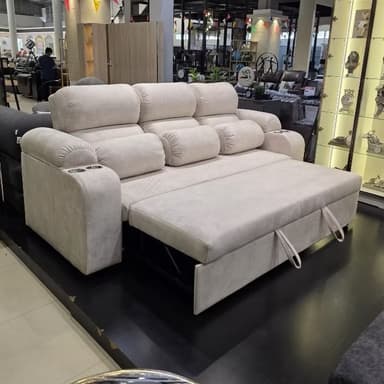 A light-colored sofa bed with a pull-out sleeping surface and integrated cup holders on the armrests. The sofa features plush cushioning and includes lumbar support pillows. The frame appears to be constructed from metal for the pull-out mechanism, while the upholstery is fabric. — 3D model