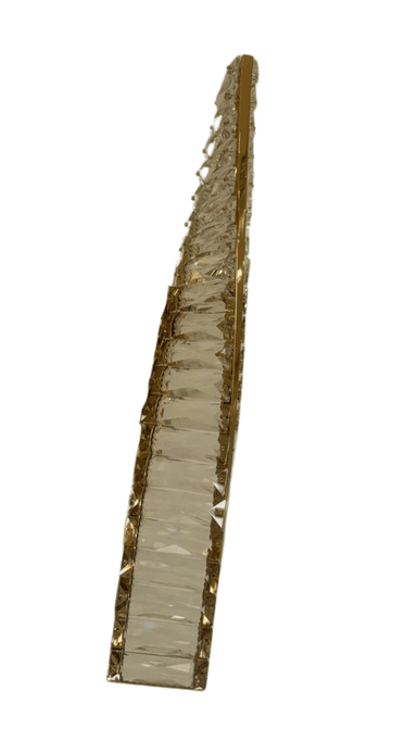 A vertical, wall-mounted lighting fixture featuring a polished gold-toned metal frame intricately embellished with numerous clear, faceted crystal elements. The crystals are arranged in a multi-tiered pattern along the central metal structure, designed to refract and reflect light. A rectangular gold-finished mounting plate is visible at the center. — 3D model