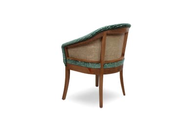 An upholstered armchair featuring a barrel-shaped back and integrated armrests, covered in a dark green velvet fabric with a textured, mottled pattern. The chair is supported by four solid wooden legs that are slightly tapered. — 3D model