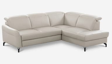 An L-shaped sectional sofa upholstered in a light beige or off-white material, likely leather or faux leather. It features a three-seater section connected to a right-hand facing chaise lounge. The backrests have distinctive padded headrest sections, and the sofa rests on sleek, minimalist black metal legs. — 3D model
