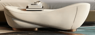 A modern, sculptural chaise lounge upholstered in a light, cream-colored material, featuring a smoothly curved form and a recessed gold-toned metallic base. — 3D model