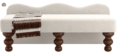 A contemporary upholstered bench featuring a distinct scalloped or wavy backrest. The bench is covered in a light, textured fabric, likely an off-white or cream linen blend. It stands on four dark, turned wooden legs, providing a classic contrast to the modern lines of the upholstered body. A brown and white striped throw blanket is draped over one end of the bench, adding a touch of warmth and texture. — 3D model