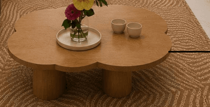 A modern low table featuring a distinctive cloud-shaped wooden tabletop supported by two stout, cylindrical wooden legs. The wood exhibits a light, natural finish with visible grain. The design emphasizes organic forms and minimalist aesthetics. — 3D model