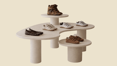 A sculptural, organic modern multi-level coffee table featuring an elongated kidney-shaped main surface and two smaller, elevated circular platforms. The entire piece is rendered in a uniform pale beige matte finish, supported by thick, cylindrical pedestal bases. — 3D model