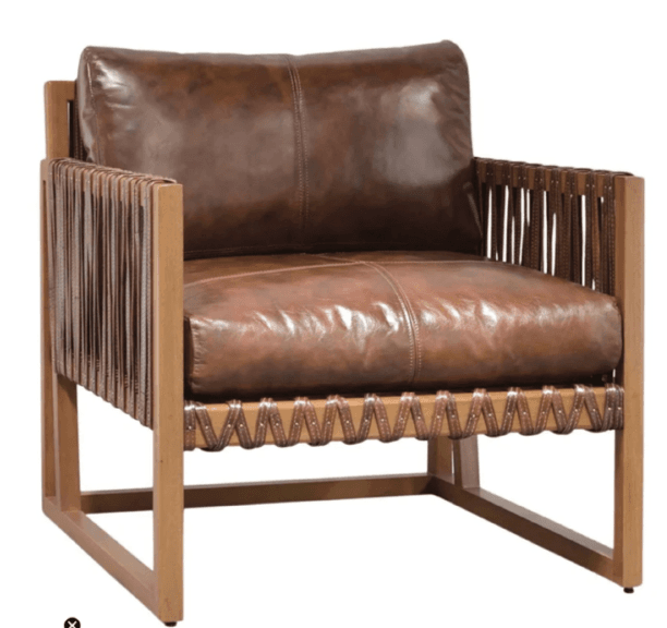 A contemporary lounge armchair featuring a robust, exposed light-toned wooden frame and plush, distressed brown leather upholstery. The design incorporates distinctive woven leather straps on the armrests and front lower rail, secured with metal studs. It has deep seat and back cushions, presenting a blend of rustic and modern aesthetics. — 3D model