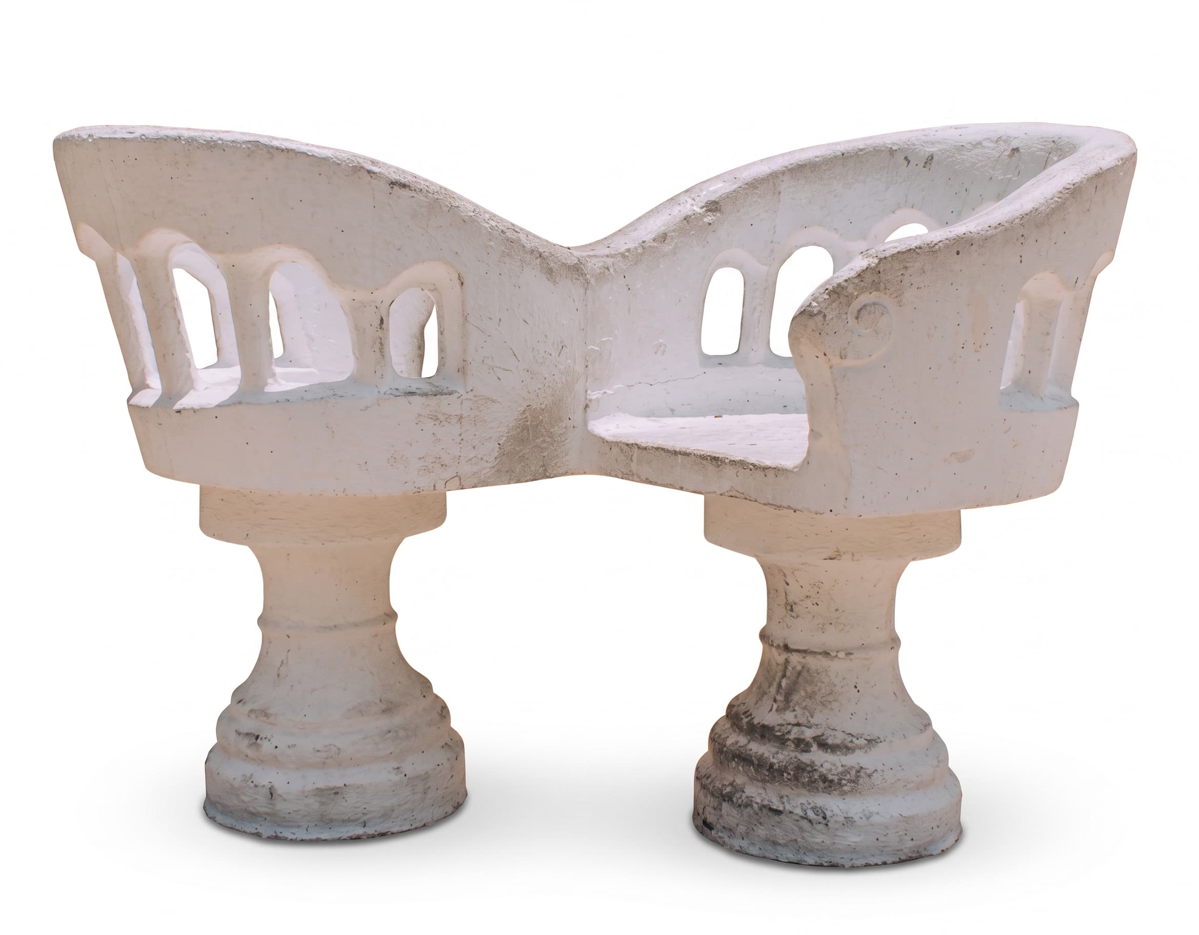A sculptural white concrete garden bench featuring two distinct seating sections supported by stout pedestal bases. The backrest and armrests form a continuous, curved structure with arch-like cutouts, giving it an architectural and organic appearance. The material shows signs of weathering and age. — 3D model