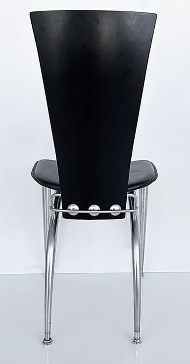 A modern chair featuring a black, curved backrest and a black, cushioned seat. The frame and four tapered legs are constructed from brushed metal, offering a sleek, contemporary aesthetic. The seat appears to be upholstered, possibly in leather or a similar synthetic material, and is supported by a silver-toned metal frame that extends to the legs. — 3D model