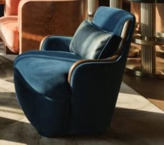 A contemporary armchair with deep blue fabric upholstery and a distinctive curved exposed wood frame. The chair features a plump, integrated seat cushion and a loose back cushion, designed for comfort and style. — 3D model