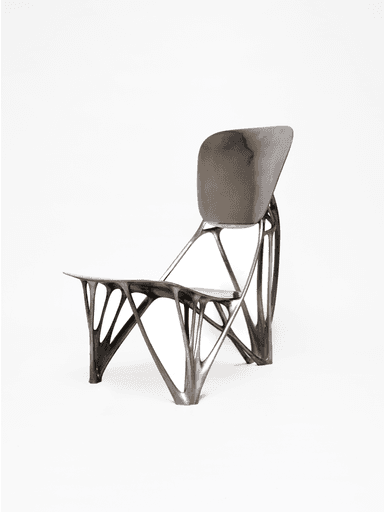 A contemporary chair featuring an intricate, dark-colored biomorphic skeletal base that supports a smoothly contoured, matte grey seat and backrest. The design is sculptural and avant-garde. — 3D model