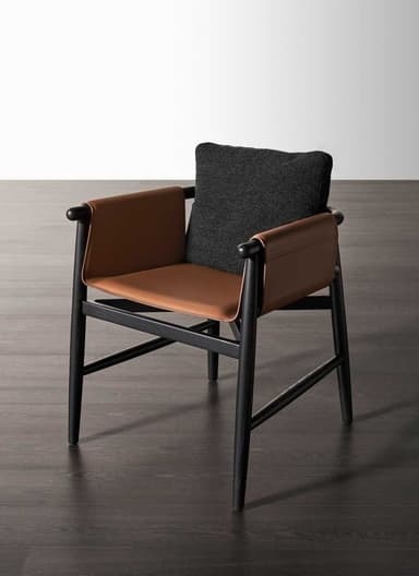 A contemporary armchair featuring a dark-stained solid wood frame, tan leather sling seat and armrests, and a dark gray fabric back cushion. The design is minimalist with clean lines and rounded details on the armrests. — 3D model