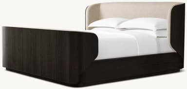 A modern platform bed featuring a dark wood frame with distinct graining and gently curved corners. The headboard is integrated, upholstered in a light, neutral fabric, and extends along the sides, enveloping the sleeping area. The bed has a low-profile base, suggesting a platform design that does not require a box spring. White bedding is present, indicating its function. — 3D model