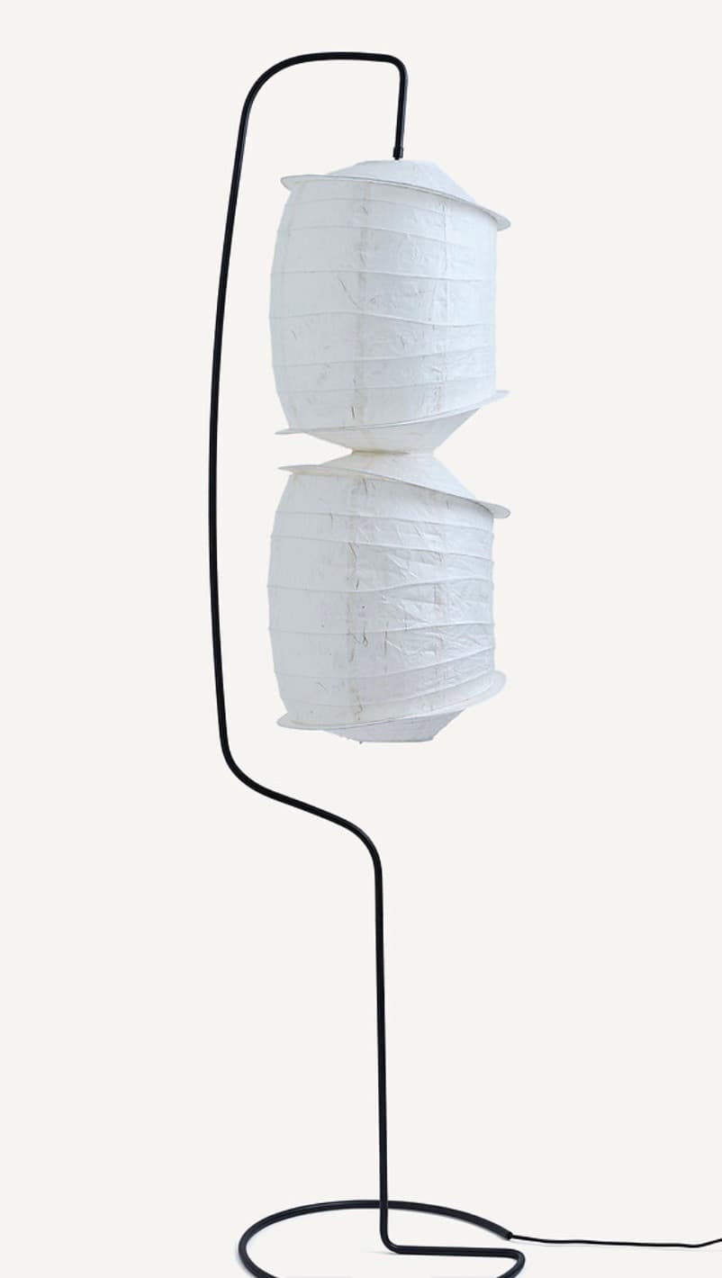 A floor lamp with a slender black metal stand and two stacked, lantern-like shades made of white textured paper. The shades have a layered, cylindrical form with slightly flared rims and horizontal pleating. — 3D model