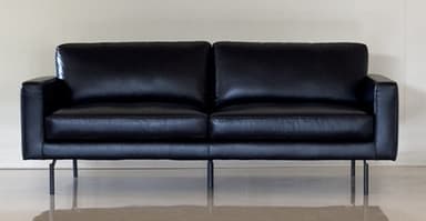 A modern two-seater loveseat upholstered in black leather, featuring a clean, minimalist design. It has two distinct seat cushions and two back cushions, straight square arms, and is supported by four slender, dark-finished metal legs that provide a floating appearance. — 3D model