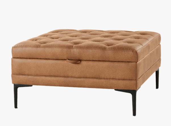 A square, tufted ottoman upholstered in distressed cognac brown faux leather, featuring a lift-top lid for hidden storage and supported by four angled black metal legs. — 3D model