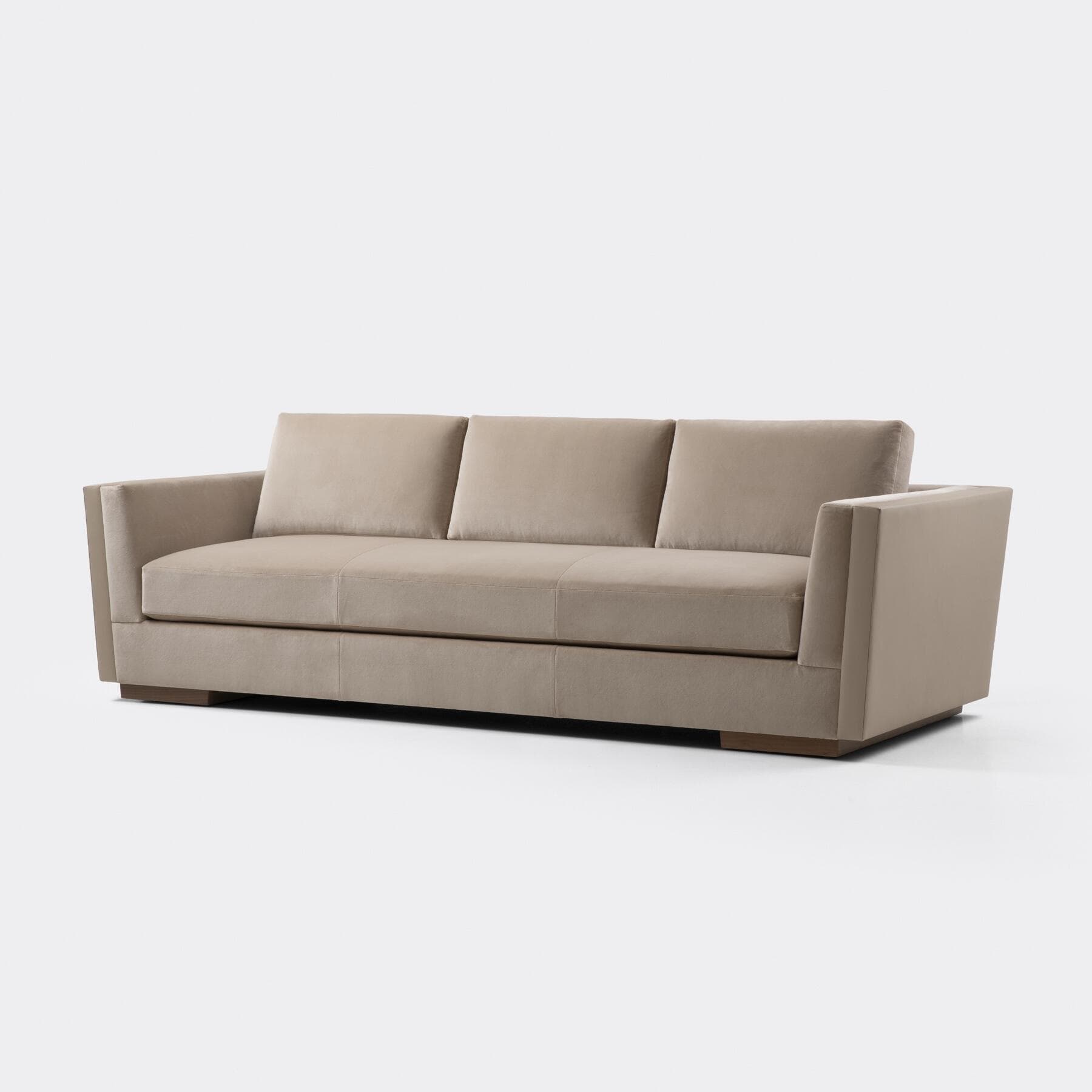 A modern three-seater sofa upholstered in a light beige or taupe velvet-like fabric. It features clean, straight lines, square track arms, and three distinct seat and back cushions. The sofa sits on a recessed plinth base with a visible wooden trim. — 3D model