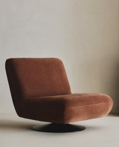A contemporary armchair with a low profile and plush upholstery. The chair features a rounded silhouette, a supportive backrest, and a deep seat. It is mounted on a circular, black swivel base, allowing for 360-degree rotation. The fabric appears to have a soft, velvety texture. — 3D model