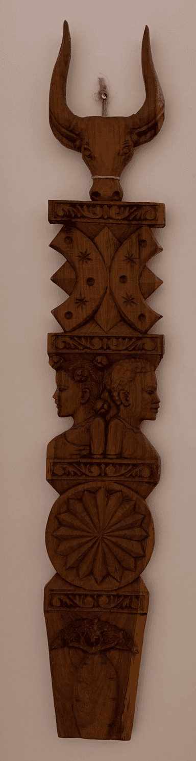An intricately carved wooden wall panel, featuring a vertical arrangement of diverse designs including a bull's head, geometric patterns, human busts, and a circular relief. The natural wood grain is visible throughout. — 3D model