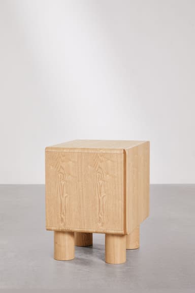 A contemporary nightstand with a cuboid main body and four cylindrical legs. The top and side panels have gently rounded edges. The grain of the wood is clearly visible, suggesting a natural wood construction. — 3D model