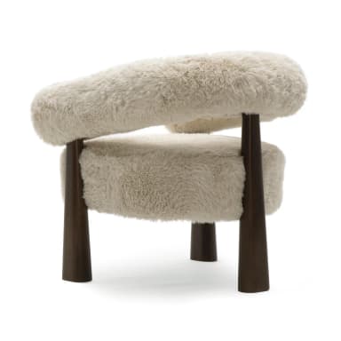 A plush, cream-colored armchair with a rounded, sculptural backrest and arms, upholstered in a shaggy faux fur. The chair is supported by four dark brown, tapered wooden legs that flare slightly outwards. Dimensions are indicated: 31.9"H x 31.2"W x 28.4"D, with seat height at 20.5"H. — 3D model