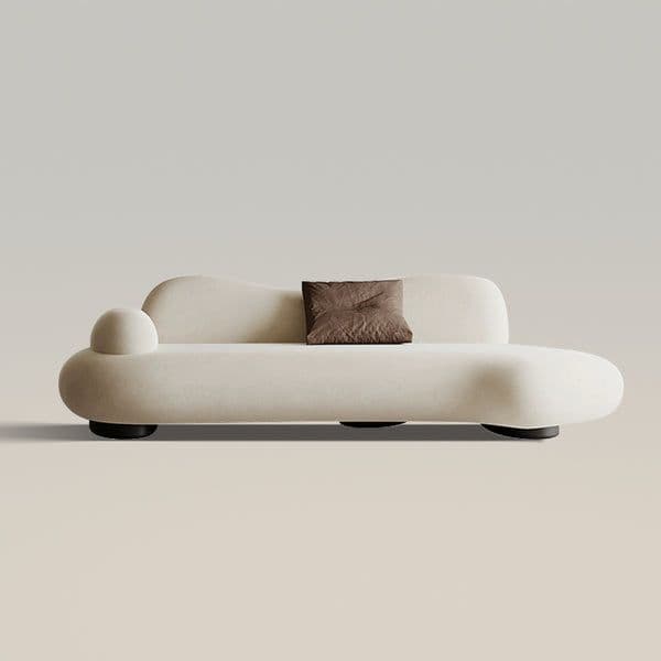 A modern, cream-colored sofa with a unique, flowing design. It features rounded, organic shapes, including a bulbous armrest on the left and an extended, rounded seating area. A single, dark brown square cushion is placed centrally on the backrest. The sofa rests on low-profile, dark circular feet. — 3D model