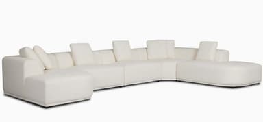 A large, contemporary modular U-shaped sectional sofa upholstered in a cream-colored fabric, featuring soft, rounded edges and a low-profile design, complete with multiple back cushions. — 3D model