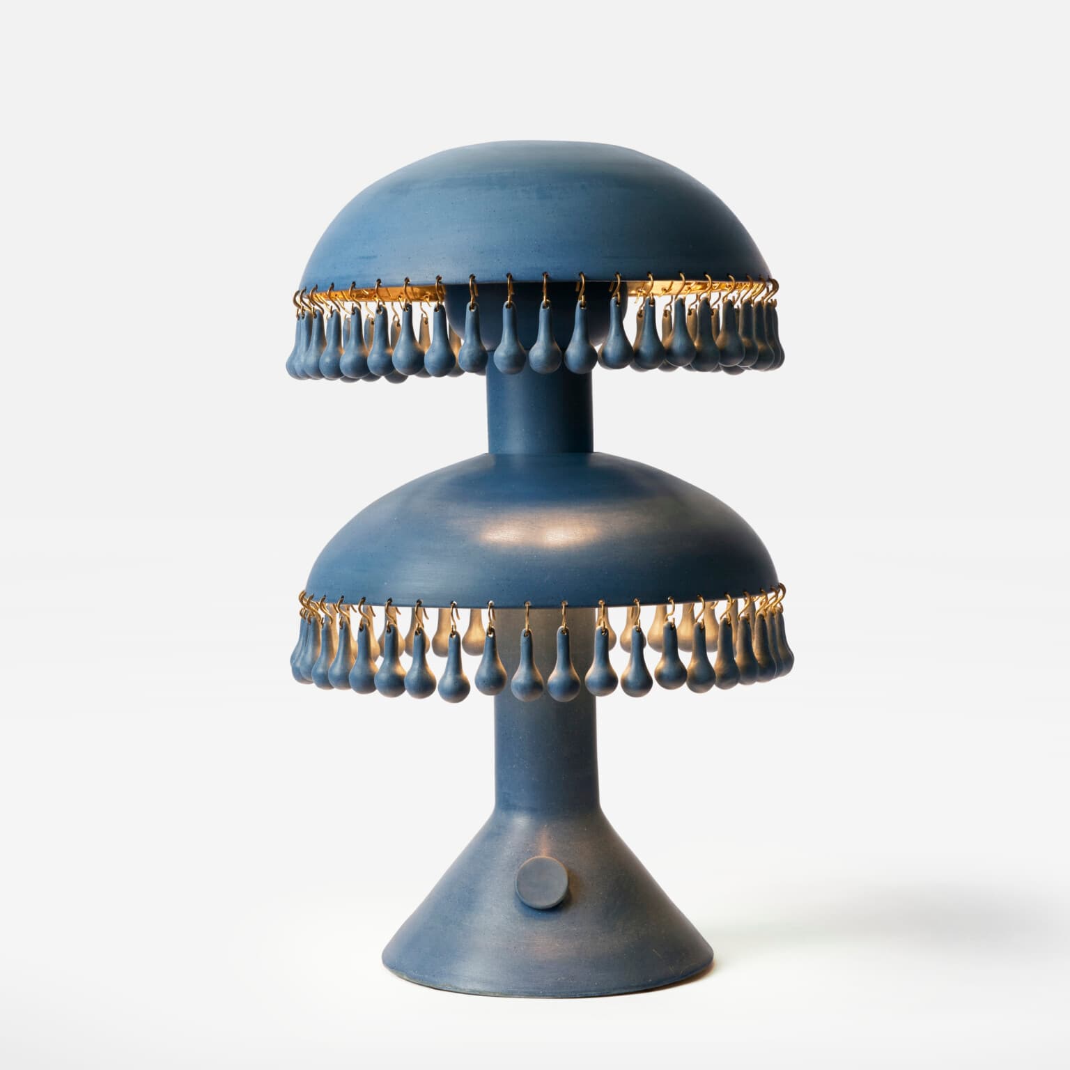 A two-tiered table lamp with a stepped base and mushroom-shaped shades. Each shade has a decorative fringe of tear-drop shaped elements suspended from a metallic ring. The lamp features a central stem connecting the two tiers and a circular on/off switch on the base. — 3D model