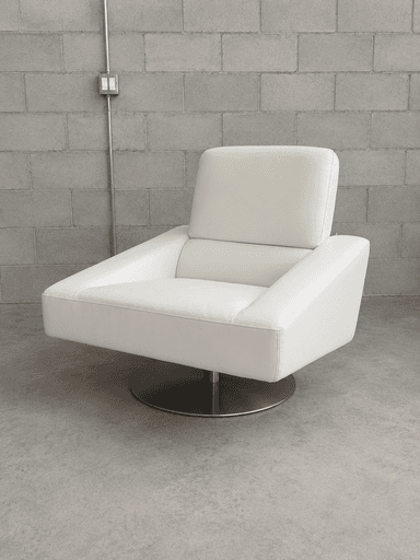 A contemporary white upholstered lounge chair featuring a low-profile design, broad rectangular armrests, and a hidden swivel base. The seating and back cushions are well-padded, providing a plush yet structured appearance. The upholstery material appears to be a smooth, off-white leather or high-quality faux leather, with precise stitching details. — 3D model