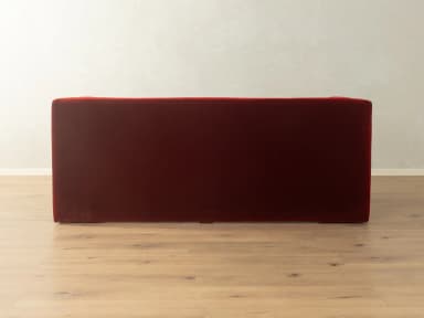 A two-seater sofa with a distinct geometric design. It features deep red velvet upholstery, high, angular armrests that extend downwards to form the base, and a single seat cushion. — 3D model