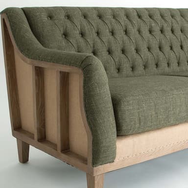 A three-seater sofa with a high back and arms. The backrest and seat cushions feature deep button tufting. The base of the sofa is constructed from a light-colored wood frame with a visible grain and is supported by four tapered wooden legs. — 3D model