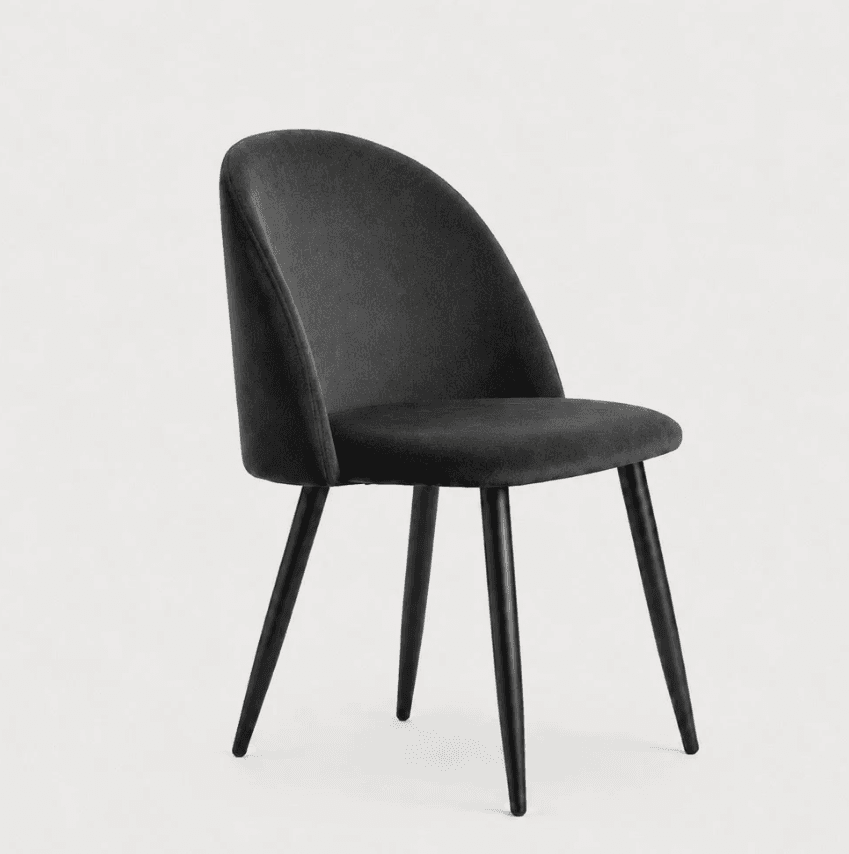 A modern dining chair featuring a gracefully curved backrest and seat, fully upholstered in dark gray velvet fabric. The chair stands on four slender, tapered metal legs finished in black, providing a sleek and stable base. The design is armless, emphasizing its compact and versatile nature suitable for various dining or accent applications. — 3D model