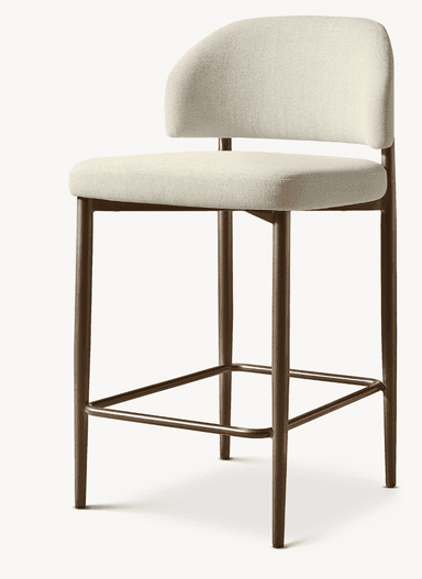 A contemporary bar stool featuring a light beige upholstered seat and a gently curved backrest, supported by a bronze-finished metal frame with an integrated square footrest. — 3D model