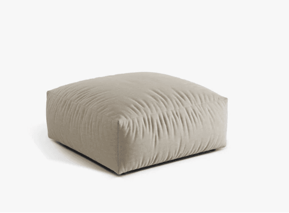 A square, low-profile upholstered ottoman in a light beige or off-white fabric, featuring a softly pleated or ruched texture across its top surface, creating a relaxed and inviting aesthetic. It is a plush, soft-sided piece designed for comfort. — 3D model