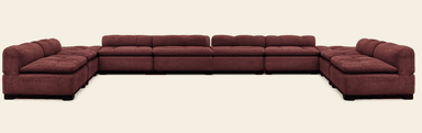 A large, modular sectional sofa arranged in an L-shape, upholstered in a reddish-brown, plush fabric. Each section features deeply tufted seat cushions and backrests, providing a comfortable and inviting appearance. The sofa sits on low, dark block feet. Its modular design allows for flexible configurations to suit various room layouts. — 3D model