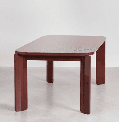 A close-up view of a table's corner and one leg. The table has a rectangular top with rounded corners and a thick, slightly beveled edge. The leg is solid and rectangular in cross-section, with a subtle taper towards the bottom and a rounded end. The design appears modern and minimalist. — 3D model